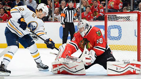 Corey Crawford zasahuje proti Marcusu Folignovi