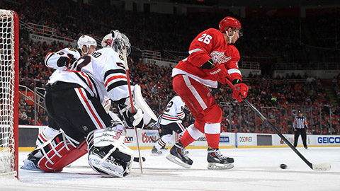 Corey Crawford při zákroku před Tomášem Jurčem