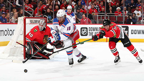 Alex DeBrincat a Marc Staal v souboji o kotouč (© Chase Agnello-Dean/NHLI via Getty Images)