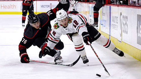 Alex DeBrincat uniká v souboji Bradymu Skjeiovi (© Gregg Forwerck/NHLI via Getty Images)